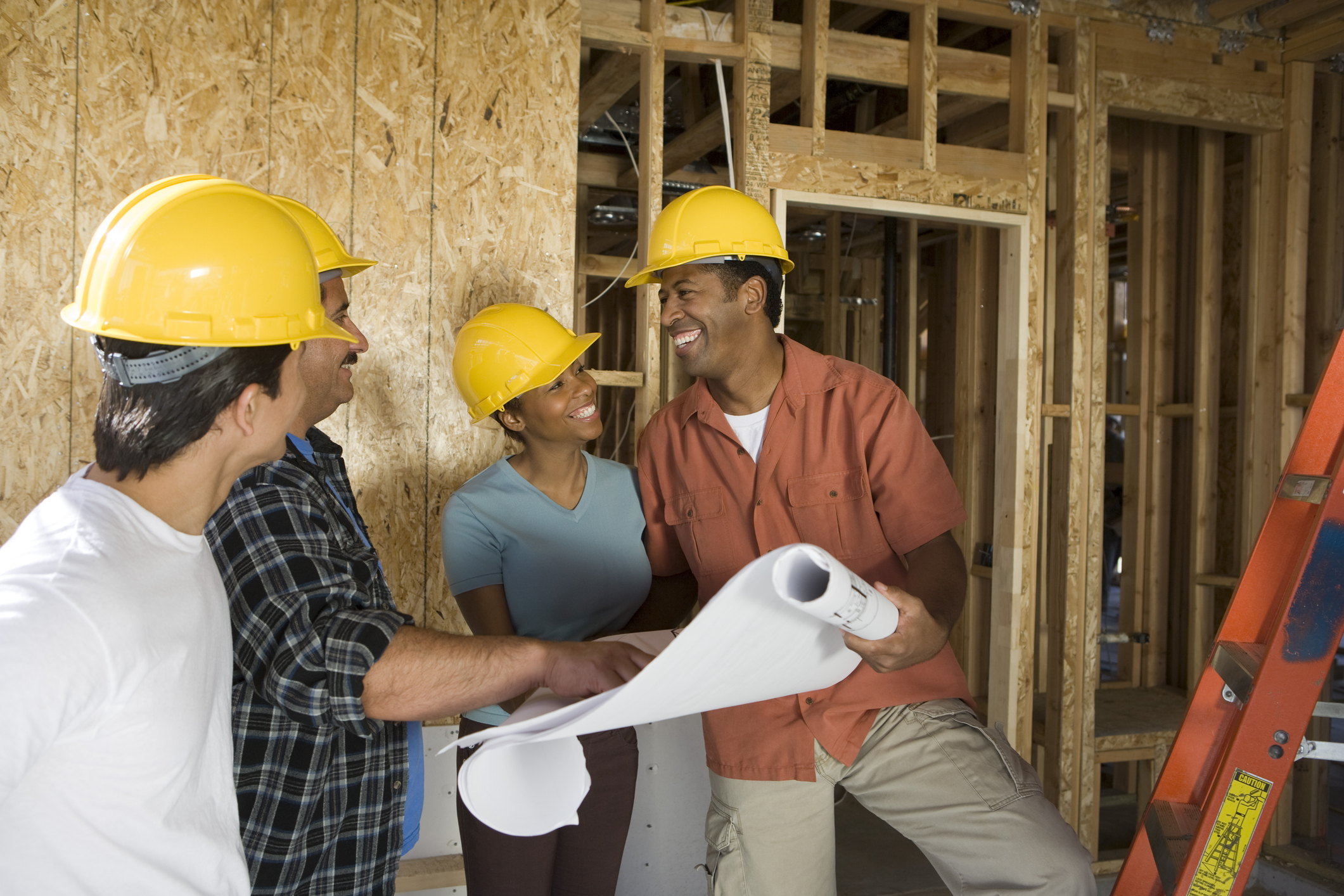 Couple consulting workers on construction site