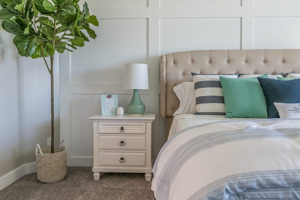 How to Create a Relaxing Bedroom Sanctuary - Wainscott and houseplants with a sliding barn door to a sunroom