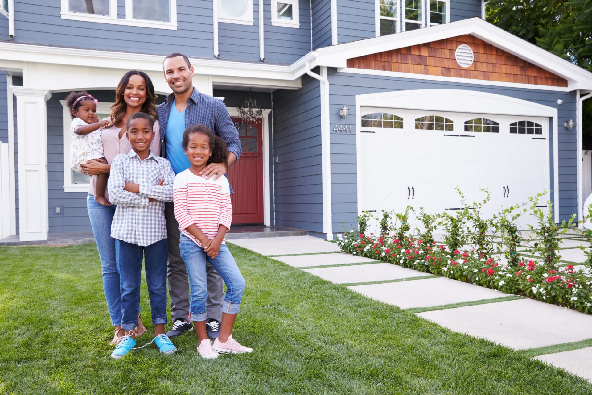 Happy black family standing outside their house