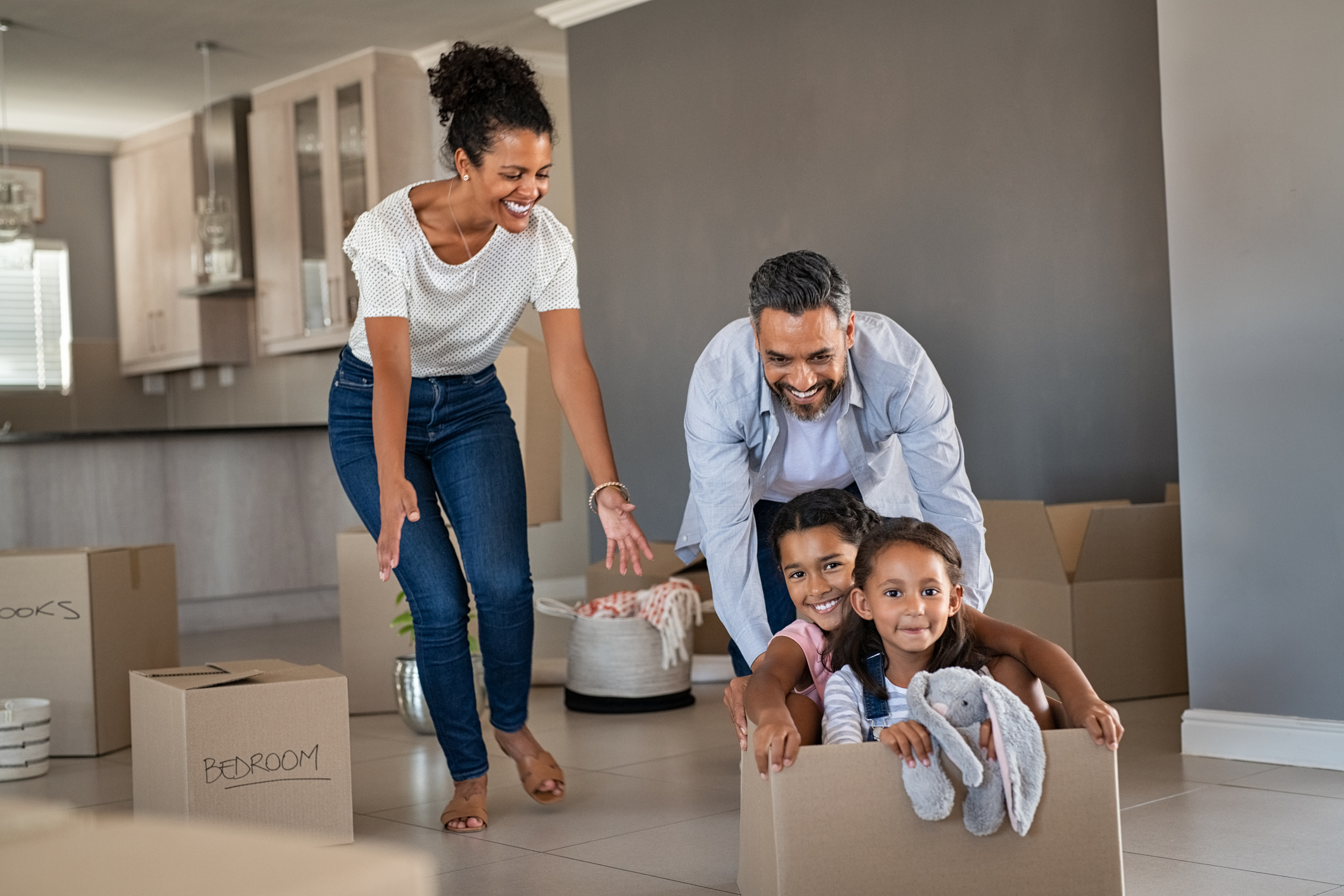 Parents playing with children while moving into new home