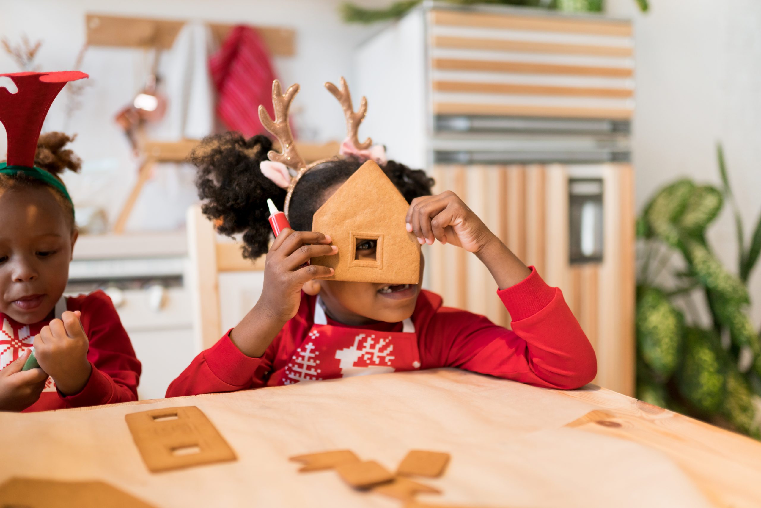 Gingerbread Decorating Day. Kids assembling tasting gingerbread house for Christmas holidays. Happy moments at home concept