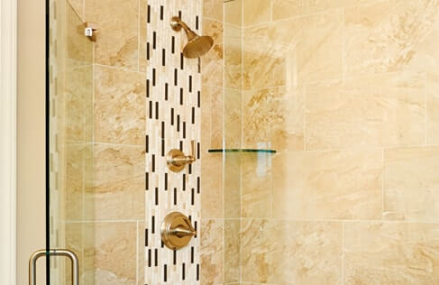 Shower with glass door, ceramic tile surround and glass corner shelf - extra tile detail around shower head and faucet handles