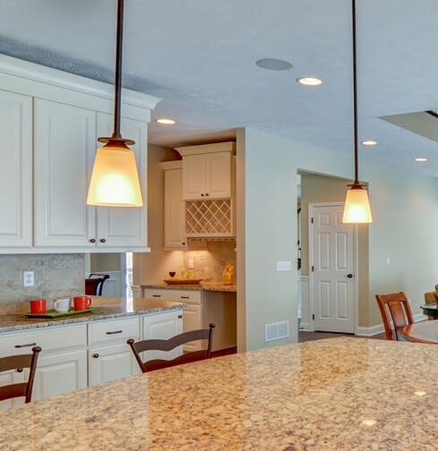 Two pendant lights over kitchen island with granite countertop