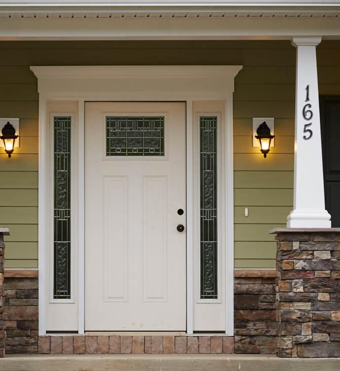 Front porch detail - white door with stained glass window inserts, partial stone kneewall and porch column with kneewall