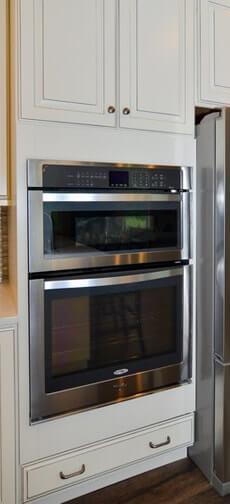 Stainless steel wall oven and microwave combination - white cabinetry above and below