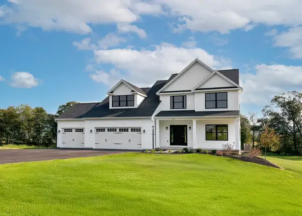 Bayberry two-story home with white siding, black shutters, covered front porch, and attached three-car front-entry garage