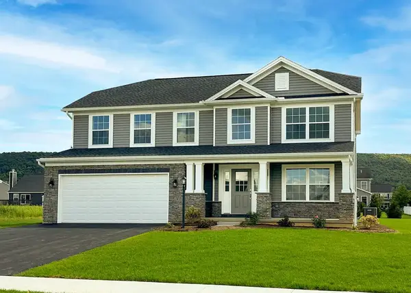 Two-story Greenwood home with mixed siding and stone, covered front porch, attached garage, and manicured lawn. 