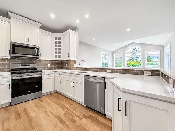 Bright Crestmont kitchen with white cabinets, quartz counters, subway tile backsplash, and sunlit morning room