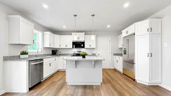 Hawthorne kitchen with white cabinets, granite countertops, center island, stainless appliances, and vinyl plank flooring.