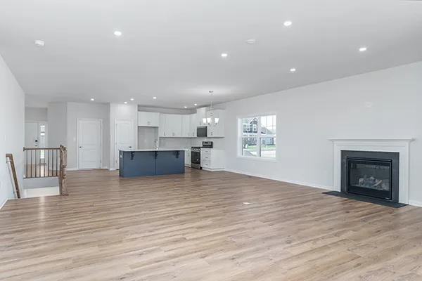 Aspen family room, dining area, and kitchen with open-concept layout, recessed lighting, vinyl plank flooring, and an unfurnished interior.