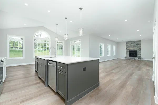 Newport kitchen with oversized island, pendant lighting, vinyl plank flooring, and open views to the morning room and family room.