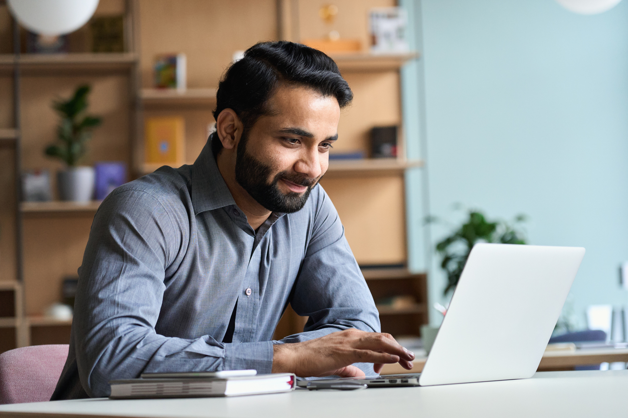 Man sitting in his home office submitting a service checklist from his laptop.